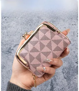 Close-up of pink and black geometric pattern mini coin purse with gold kiss-lock