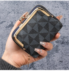 Close-up of compact geometric textured wallet with golden metal clasp and zipper detail