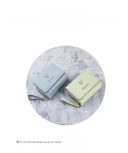 Detail of mini PU leather wallet featuring metal deer head ornament and zip closure