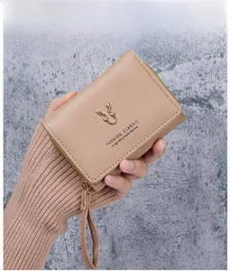Detail of pink PU leather wallet featuring metal antler decor and zipper closure