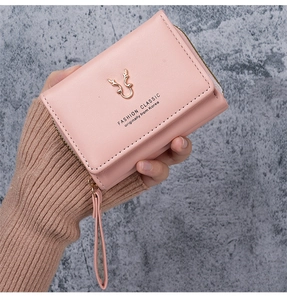 Close-up of pink PU leather trifold wallet featuring golden deer icon and smooth zipper