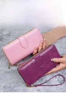 Détails des portefeuilles en cuir ciré rose et violet avec fermeture éclair et dragonne