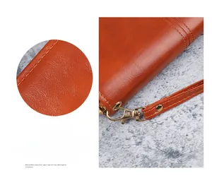 Détail du portefeuille en cuir ciré vintage avec texture lychee et dragonne amovible