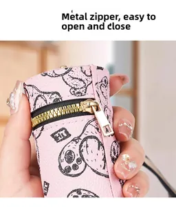 Macro detail of a pink leather coin purse featuring a cartoon print and metal zipper