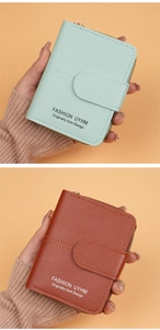 Detail of short leather wallet in mint green and reddish brown with wrap zipper