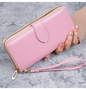 Détail du portefeuille en cuir ciré rose avec dragonne et fermeture éclair dorée