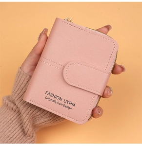 Close-up of pink lychee textured leather wallet held in hand with L-shaped zipper