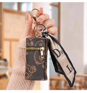 Detailed close-up of a mini leather pouch featuring vintage bear patterns and silk scarf decor