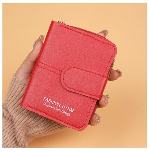 Close-up of red pebbled leather women's short wallet with zip and buckle closure