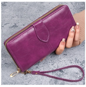 Détail du portefeuille long en cuir ciré violet avec fermeture éclair et dragonne