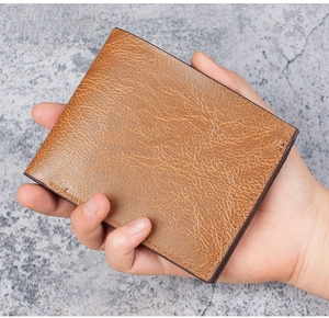 Close-up of a brown vintage leather wallet with textured surface and durable stitching