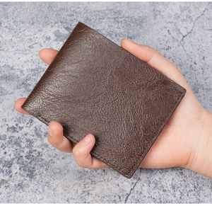 Close-up of brown bifold men's wallet showing litchi grain texture and neat stitching