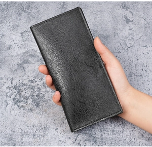 Close-up of litchi textured leather on a slim long wallet held by a hand