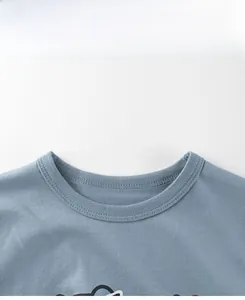 Detail view of double-stitched rib-knit crew neck on a blue cotton kids t-shirt