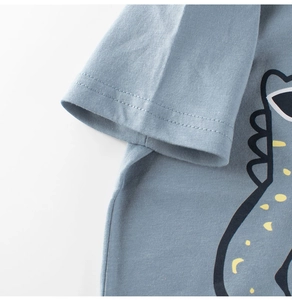 Detail of blue cotton T-shirt featuring cartoon dinosaur print and high-quality sleeve stitching