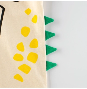 Détails d'un t-shirt dinosaure avec pois jaunes et pointes dorsales vertes en 3D