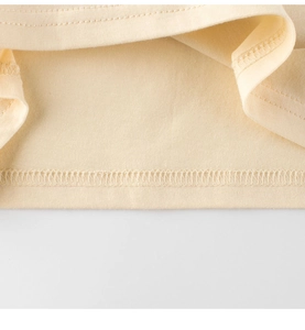 Détails de couture et de finition de l'ourlet sur ce t-shirt en coton pour enfants