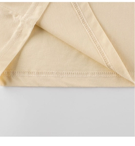 Vue détaillée des ourlets à double aiguille sur un t-shirt en coton beige pour enfants