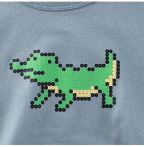 Dettaglio di una maglietta in cotone celeste con una grafica a coccodrillo pixel