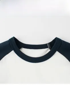 Détail des coutures plates et de l'encolure raglan contrastée du t-shirt blanc en coton garçon