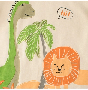 Close-up of soft cotton kids T-shirt with cartoon dinosaur, lion and palm tree print
