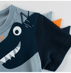 Detailed close-up of boys dinosaur t-shirt with 3D orange spikes and cotton rib neckline