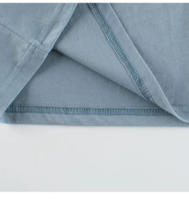 Detailed close-up showing the professional double-needle hem stitching on a blue cotton T-shirt