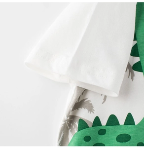 Close-up of kids cotton t-shirt showing green cartoon dinosaur print and sleeve stitching