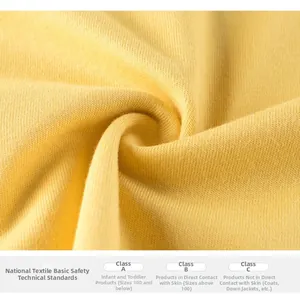 Macro view of bright yellow cotton knit fabric with soft texture and safety grade text