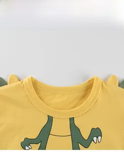 Detail of yellow cotton kids T-shirt featuring a ribbed crew neck and 3D dinosaur back fins