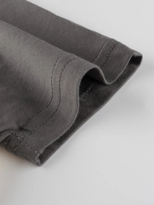 Close-up of premium dark grey cotton t-shirt sleeve with durable double needle stitching