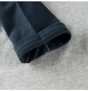 Detailed close-up of double-stitched hem and seams on navy blue knit cotton sleeves