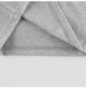 Detail of gray cotton knit fabric showing precise double-needle stitching and soft hemline