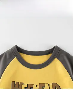 Detail of the crew neck and raglan sleeve stitching on this kids yellow weekend t-shirt