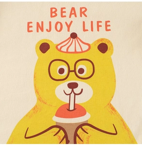 Detail of cartoon bear illustration with Bear Enjoy Life text on a beige cotton t-shirt