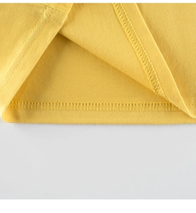 Detailed close-up of double-needle stitching on yellow cotton jersey t-shirt hem