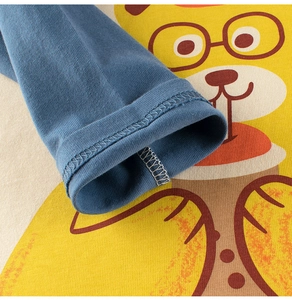 Close-up of contrast blue ribbed cuffs and cartoon bear print on cotton kids t-shirt
