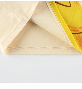 Close-up of beige cotton kids T-shirt hem showing precise double-needle stitching detail