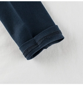 Vista macro de puños azul marino con doble costura en camiseta de algodón para niños