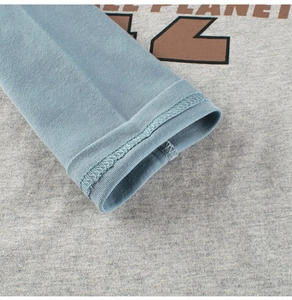 Close-up of blue ribbed cuffs and cotton fabric with Planet 12 print on grey shirt