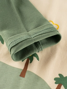Close-up of olive green cuffs and cotton knit fabric of dinosaur cartoon t-shirt for boys