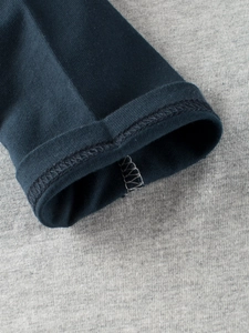 Detail of premium stitching on kids long sleeve raglan t-shirt with navy and grey cotton fabric
