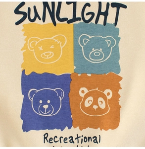 Detail of cream knit sweater with cartoon bear print and SUNLIGHT lettering