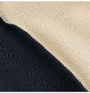 Detailed macro view of two-tone navy and cream sherpa fleece fabric with sturdy stitching