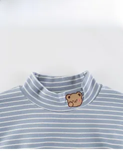 Detail of blue and white striped kids shirt with cute brown bear embroidery on collar