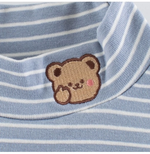 Detailed macro view of kids striped sweater neck with cute brown bear embroidery