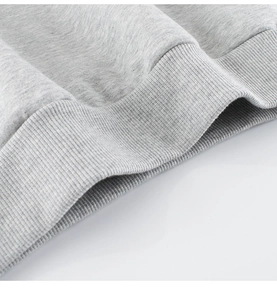Detail of light gray marl sweatshirt showing soft knit fabric and ribbed cuff texture
