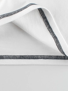 Primer plano de camiseta blanca de manga larga con costuras overlock negras en contraste
