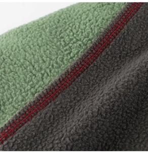 Detail of polar fleece fabric with contrast red stitching and two-tone color block design