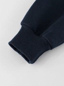 Close-up of navy blue ribbed cuffs on children's crewneck sweatshirt with knit texture